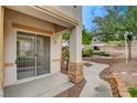 Charming patio area featuring a sliding glass door and stone accents leading to lush landscaping at 232 Morgyn Ln # 6, Boulder City, NV 89005