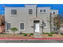 An exterior view of a multi-story stucco house with a front yard and stone landscaping at 2612 Kindness Ct, North Las Vegas, NV 89031