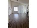 Bright living room featuring wood floors, a fireplace, and large windows that provide ample natural light at 3324 Haven Beach Way, Las Vegas, NV 89117