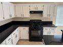 Modern kitchen featuring white cabinets and black appliances, including a gas range at 3641 Spring Day Ct, Las Vegas, NV 89147