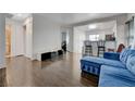 Bright living room with wood floors, adjacent to the kitchen, and furnished with a comfortable blue sofa at 5438 Jacobs Field St, Las Vegas, NV 89148