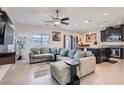 Spacious living room with a large sectional couch, ceiling fan, and tile flooring at 5556 Cornadelo Range Rd, Las Vegas, NV 89113