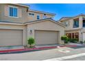 Attached two-car garages with neutral doors, framed by well-kept landscaping and a clearly marked fire lane at 5730 Sky Pointe Dr # 104, Las Vegas, NV 89130