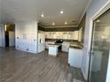 Bright kitchen with white cabinetry, an island with light countertop, black appliances, and tiled floors at 5846 Lee Fairy Ct, Las Vegas, NV 89139