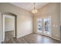 Cozy dining area featuring wood-look floors, french doors, and a charming chandelier at 6617 Lavender Lilly Ln # 1, North Las Vegas, NV 89084