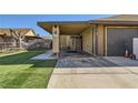 Back exterior featuring covered parking and manicured lawn at 7047 Mountain Meadow Ln, Las Vegas, NV 89147