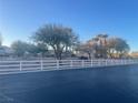 Beautiful community landscape featuring mature trees and a white fence, creating a serene and inviting environment at 8787 Tom Noon Ave # 101, Las Vegas, NV 89178