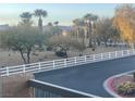 Scenic community view with desert landscaping, mature trees, and white fencing, creating a peaceful outdoor setting at 8787 Tom Noon Ave # 101, Las Vegas, NV 89178