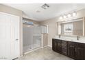 Bathroom featuring glass enclosed shower, dual sink dark wood vanity, and neutral finishes at 9277 Ardoa Ave, Las Vegas, NV 89148