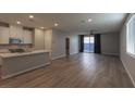 A light and bright living room features hardwood flooring and a view of the kitchen and outdoor space at 9428 Noble Fir Ridge Ave, Las Vegas, NV 89143