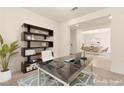Home office featuring a modern desk, shelving, and a view to a dining room in the background at 9519 Wild Valley Ave, Las Vegas, NV 89148