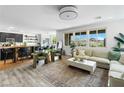 Open concept living room with large windows, modern furnishings, and views of the kitchen at 10305 Turia Gardens Rd, Las Vegas, NV 89135