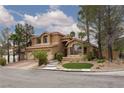 Charming two-story home with a three-car garage and beautifully landscaped front yard on a sunny day at 10325 Falls Church Ave, Las Vegas, NV 89144