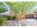 Charming two-story home with a two-car garage, landscaped front yard with lush green trees, and a brick driveway at 1035 Spotted Saddle St, Henderson, NV 89015