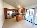 Modern kitchen with stainless steel appliances, an island, and a sliding glass door at 1208 Winwood St, Las Vegas, NV 89108