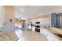 Bright kitchen featuring stainless steel appliances, granite countertops, and tile flooring throughout at 1466 Fieldbrook St, Henderson, NV 89052