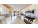 Well-lit kitchen with white cabinetry, granite countertops, and stainless steel appliances at 1466 Fieldbrook St, Henderson, NV 89052