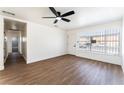 Open living area with wood floors, new ceiling fan, and access to the bathroom and hallway at 1648 J St, Las Vegas, NV 89106