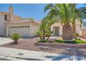 Lovely single-story home with desert landscaping, mature palm trees, and a well-maintained yard at 1751 Juniper Twig Ave, Las Vegas, NV 89183