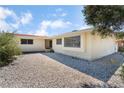 Close up of exterior of single story home with white gravel landscaping, bay window and covered entrance at 1905 Aquarius Dr, Las Vegas, NV 89102