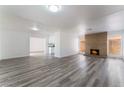 Bright living room with wood-look floors, brick fireplace, and abundant natural light with easy flow to kitchen at 1905 Aquarius Dr, Las Vegas, NV 89102