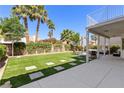 Backyard view showcasing a well-manicured lawn with stone accents and a covered patio space at 191 Reed Ln, Henderson, NV 89074