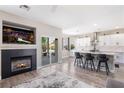 Stylish open-concept kitchen and living room area with a fireplace, backyard access, and modern kitchen island at 191 Reed Ln, Henderson, NV 89074
