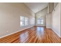 Bright and spacious living room featuring hardwood flooring, large windows, and vaulted ceilings at 1933 Coralino Dr, Henderson, NV 89074