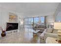 Bright living room with a tan sofa, city views, and marble flooring at 205 E Harmon Ave # 306, Las Vegas, NV 89169