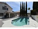Backyard oasis with a sparkling swimming pool, spa, covered patio, and lush landscaping at 2305 Flower Spring St, Las Vegas, NV 89134