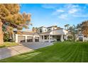 Beautiful home showcasing a well-maintained lawn, arched windows, and a three-car garage at 2316 Prometheus Ct, Henderson, NV 89074