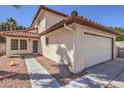 Exterior view of a two-story home with a tile roof, a two-car garage, and a landscaped walkway to the entrance at 2501 Muirfield Ave, Henderson, NV 89074