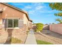 Beautiful home exterior with stone accents, desert landscaping, and a private walkway at 2720 Mickey Mantle Ct, Las Vegas, NV 89108