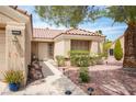 Inviting front entrance with well-manicured desert landscaping and a lighted walkway to the front door at 2737 Tumble Brook Dr, Las Vegas, NV 89134