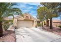 Inviting single-story home with a two-car garage, desert landscape, mature trees, and a tile roof at 2737 Tumble Brook Dr, Las Vegas, NV 89134