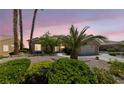 Inviting single story home at twilight with mature landscaping and attached two car garage at 3016 High Range Dr, Las Vegas, NV 89134