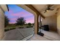 Covered outdoor patio with fan overlooks the lush green lawn and landscaping at 3016 High Range Dr, Las Vegas, NV 89134