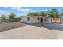 Single-story home showing long driveway, covered parking, metal security bars and fencing at 3320 Osage Ave, Las Vegas, NV 89101