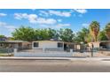 Inviting single-story home featuring a black metal fence and mature trees in a sunny neighborhood at 3320 Osage Ave, Las Vegas, NV 89101