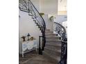 Grand foyer featuring a curved staircase with decorative iron railings and a stylish console table at 3749 Climbing Rose St, Las Vegas, NV 89147
