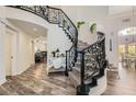Elegant staircase showcasing wrought iron railings, carpeted steps and wood flooring at 3749 Climbing Rose St, Las Vegas, NV 89147