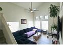 Bright living room featuring high ceilings, large windows, a ceiling fan and a large sofa at 3871 Sir Bret Ct, Las Vegas, NV 89104