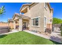 Spacious backyard with a covered patio, lush artificial grass, and privacy fencing at 415 Carsin Wayne Ct, North Las Vegas, NV 89031