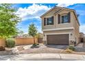 A tan two-story home with a brown roof, shutters, and a two-car garage with desert landscaping at 415 Carsin Wayne Ct, North Las Vegas, NV 89031