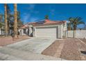 Single-story home with a two-car garage and a well-maintained driveway, showcasing desert landscaping at 4212 Herblinda Ln, North Las Vegas, NV 89032