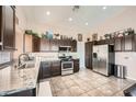 Well-lit kitchen featuring stainless steel appliances, granite countertops, tile flooring, and ample cabinet space at 4212 Herblinda Ln, North Las Vegas, NV 89032