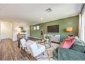 Bright living room with white chairs, green sofa, and modern decor at 5722 Sunset Sedona St # Lot 7, North Las Vegas, NV 89081