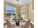 Charming dining area with a glass table set, stylish chandelier, and a bright window at 698 S Racetrack Rd # 412, Henderson, NV 89015