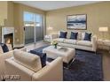 Bright living room with modern furniture, a fireplace, and sliding glass doors to outdoor space at 698 S Racetrack Rd # 412, Henderson, NV 89015