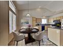 Bright dining area featuring modern lighting, a round table, and an adjacent kitchen with appliances at 7417 Red Eagle St, Las Vegas, NV 89131
